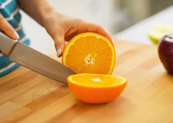 Close-up em mulher cortando laranja — Fotografia de Stock