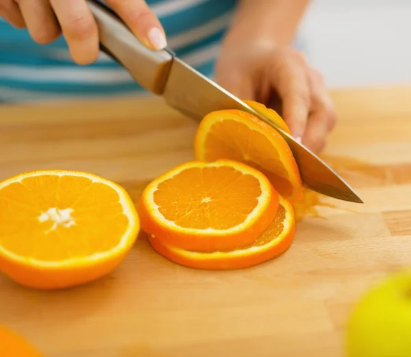 Nahaufnahme einer Frau, die Orange schneidet — Stockfoto
