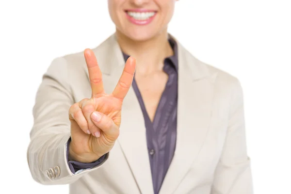 Primo piano sulla donna d'affari sorridente che mostra il gesto della vittoria — Foto Stock