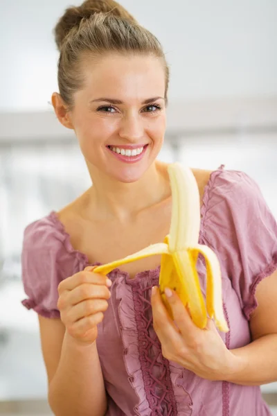 Μπανάνα peeling ευτυχής νεαρή νοικοκυρά στην κουζίνα — Φωτογραφία Αρχείου