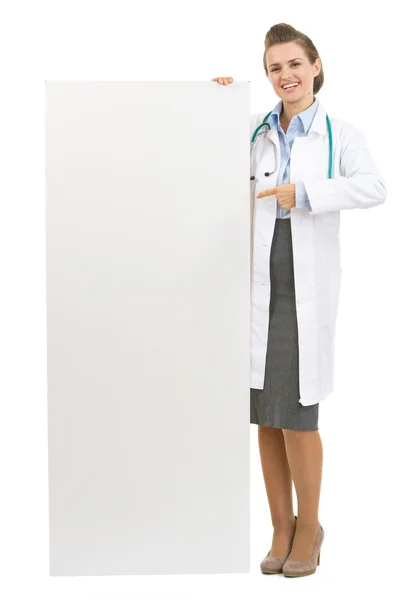 Retrato de mulher médica apontando em cartaz em branco — Fotografia de Stock