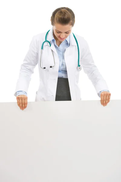 Жінка-лікар дивиться на порожній рекламний щит — стокове фото