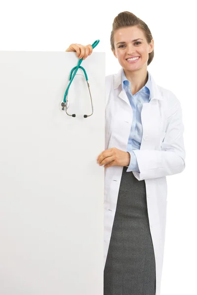 Glückliche Ärztin mit Stethoskop zeigt leere Plakatwand — Stockfoto