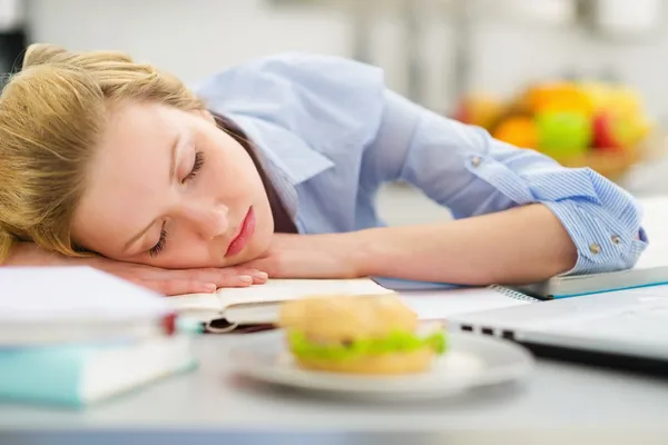 Adolescente niña se duermen mientras estudia en la cocina Imágenes De Stock Sin Royalties Gratis