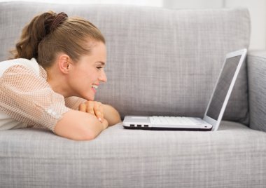 mutlu genç kadın laptop ile koltuk döşeme