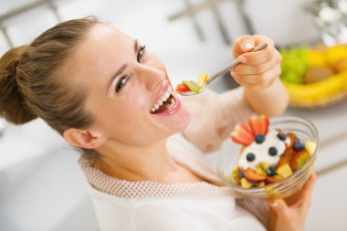 meyve salatası yerken mutlu genç ev hanımı