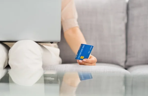 Primer plano en la tarjeta de crédito en la mano de la mujer con el ordenador portátil —  Fotos de Stock