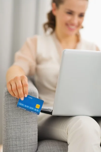 Närbild på kreditkort i handen av kvinna med laptop — Stockfoto