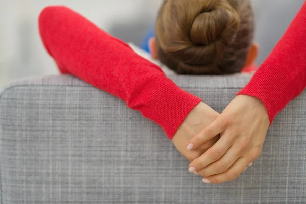 Closeup on hands of young woman laying on divan in living room. — Stock Photo, Image