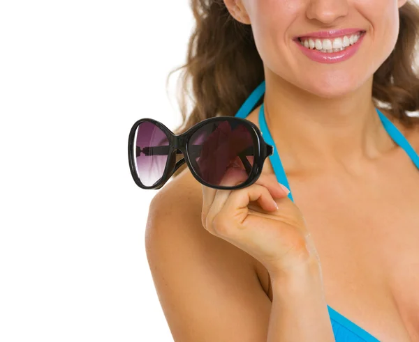 Крупним планом на молоду жінку в купальнику тримає сонцезахисні окуляри — стокове фото