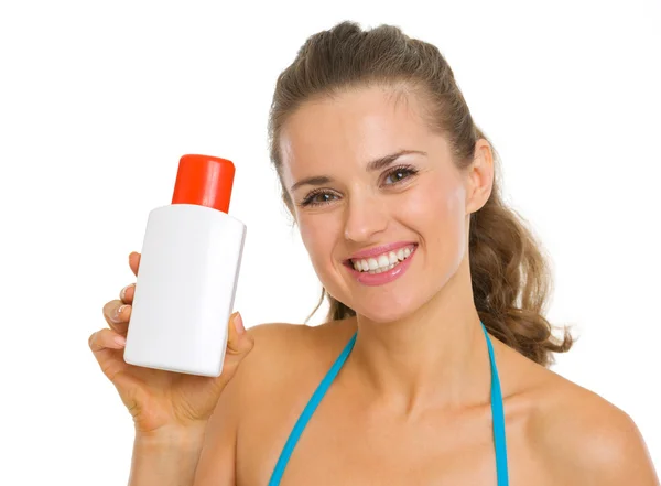 Portrait of happy young woman in swimsuit holding bottle of sun — Stock Photo, Image
