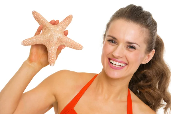 Portrait of happy young woman in swimsuit showing starfish — Stock Photo, Image