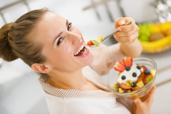 Felice giovane casalinga mangiare frutta insalata — Foto Stock