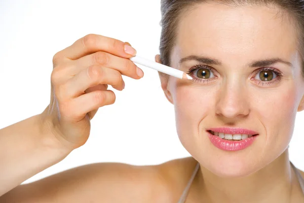 Beauty portrait of young woman applying white eye liner — Stock Photo, Image