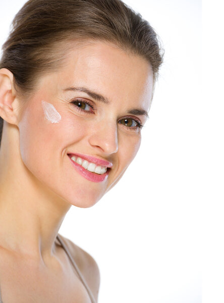 Красота портрет счастливой молодой женщины со сливками на щеке
