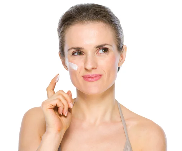 Retrato de belleza de una joven reflexiva con crema en la mejilla — Foto de Stock