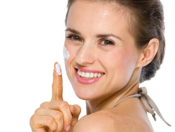 Skönhet porträtt av glad ung kvinna visar crème på finger — Stockfoto