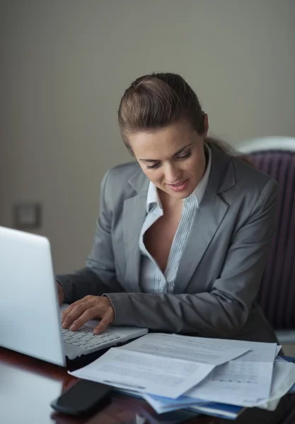 Geschäftsfrau arbeitet mit Dokumenten und Laptop — Stockfoto
