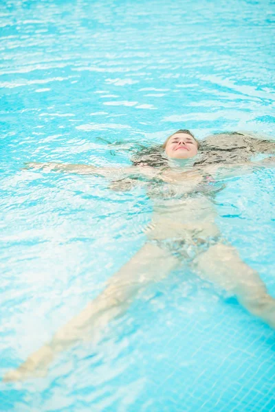 Jeune femme nageant dans la piscine — Photo