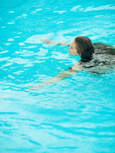 Mladá žena plavání v bazénu — Stock fotografie