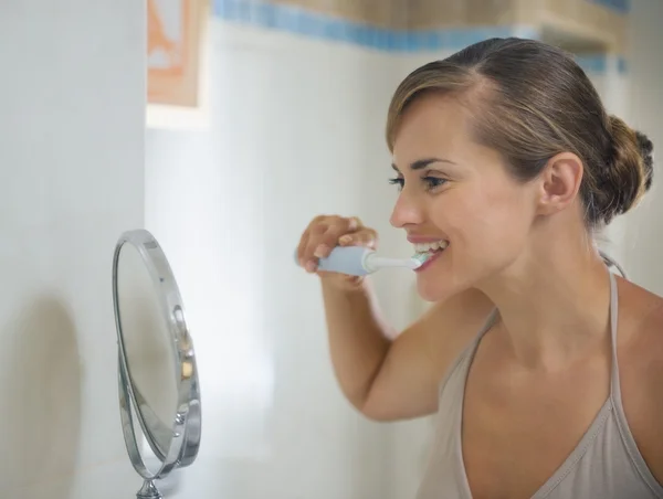Szczęśliwa młoda kobieta myjąca zęby — Zdjęcie stockowe