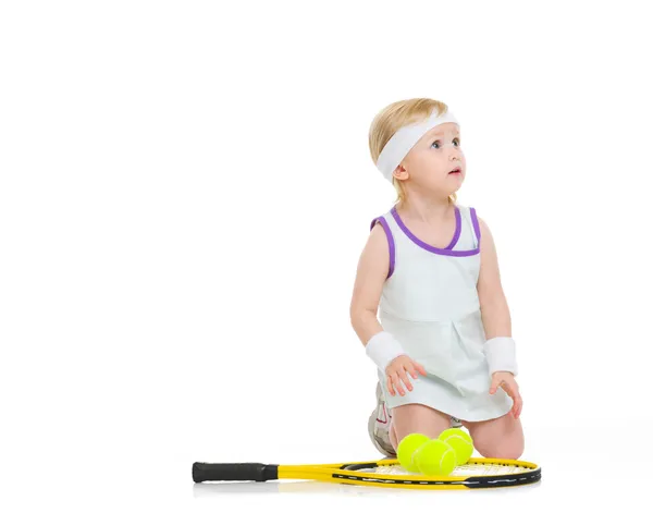 Baby in Tenniskleidung mit Schläger und Bällen — Stockfoto