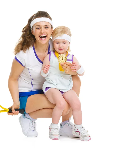 Retrato de mãe e bebê em roupas de tênis segurando medalha — Fotografia de Stock