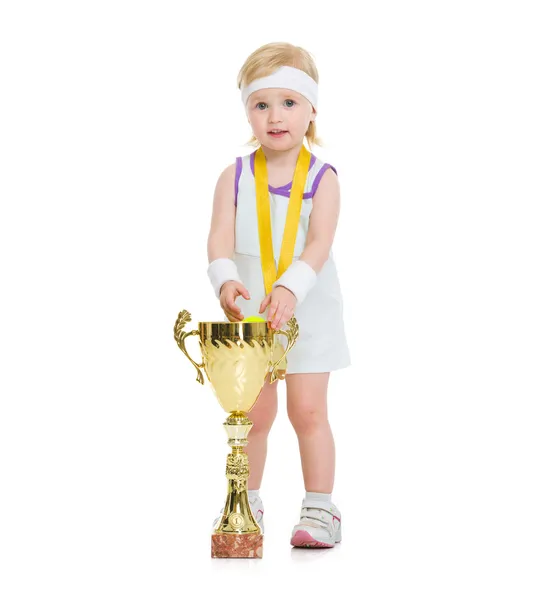 Счастливый ребенок в теннисной одежде с медалью и кубком — стоковое фото