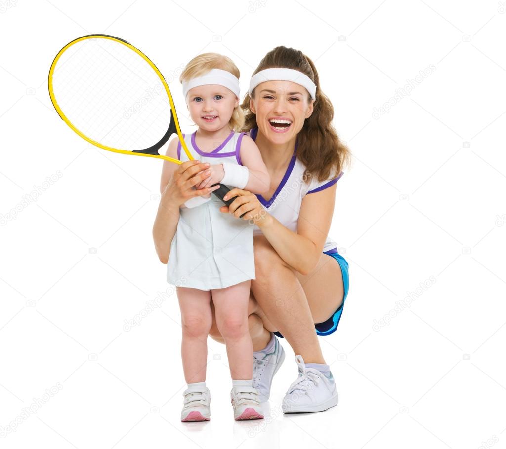 Portrait of happy mother and baby holding tennis racket