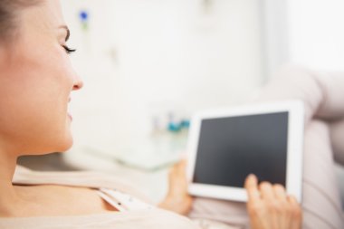tablet pc ile kanepede döşenmesi genç bir kadın. arka görünüm