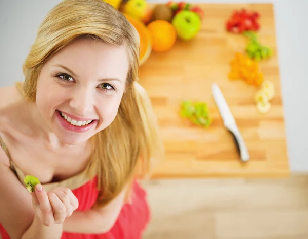 Portrét smějící se mladé ženy dělat ovoce salát — Stock fotografie
