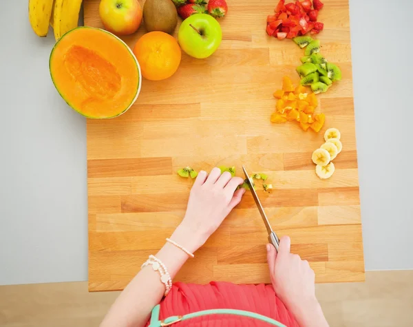 Retrato de ama de casa joven haciendo ensalada de frutas — Foto de Stock