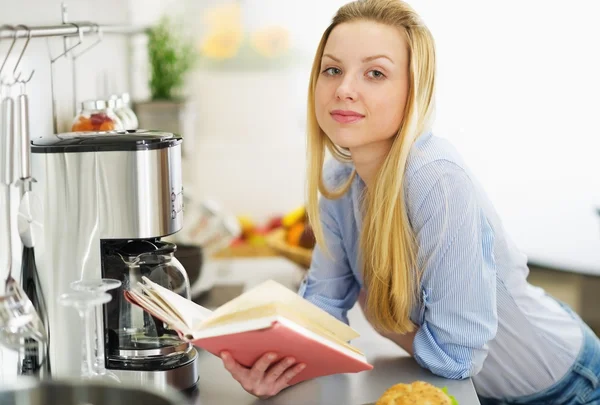 Ragazza adolescente lettura libro in cucina — Foto Stock