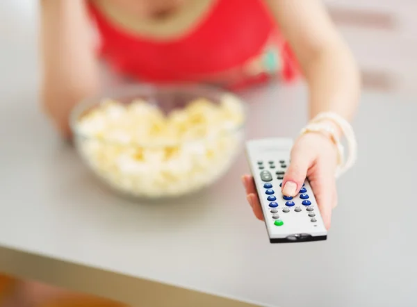 Close-up na tv controle remoto na mão de mulher jovem — Fotografia de Stock