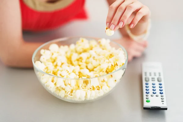 Крупным планом девушка-подросток ест попкорн и смотрит телевизор — стоковое фото