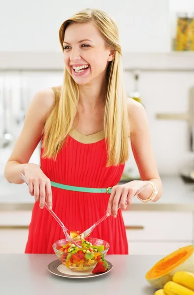 Lächelnde junge Hausfrau macht Salat — Stockfoto