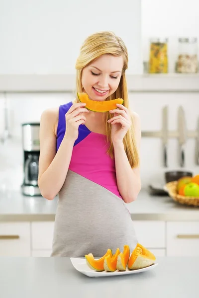 Glückliche junge Frau isst ein Stück Melone — Stockfoto