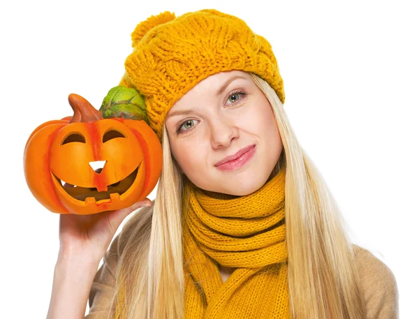 Menina de chapéu e cachecol mostrando jack-o-lanterna — Fotografia de Stock