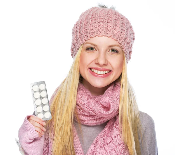 Fröhliches Teenager-Mädchen in Wintermütze und Schal mit Pillen-Packung — Stockfoto