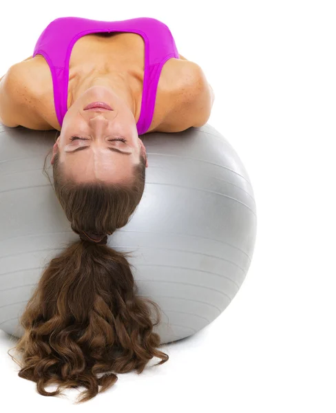 Mujer joven acostada en la pelota de fitness — Foto de Stock