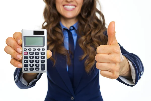 Primer plano de la sonriente mujer de negocios mostrando la calculadora y los pulgares —  Fotos de Stock