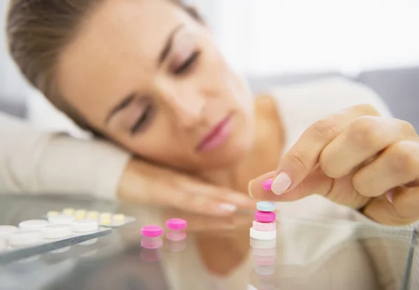 Primer plano de la joven frustrada jugando con pastillas — Foto de Stock