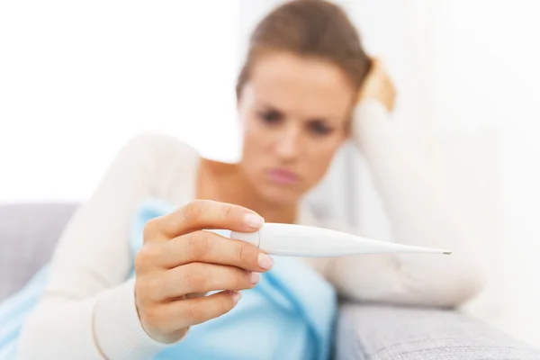 Closeup on thermometer in hand of concerned young woman — Stock Photo, Image