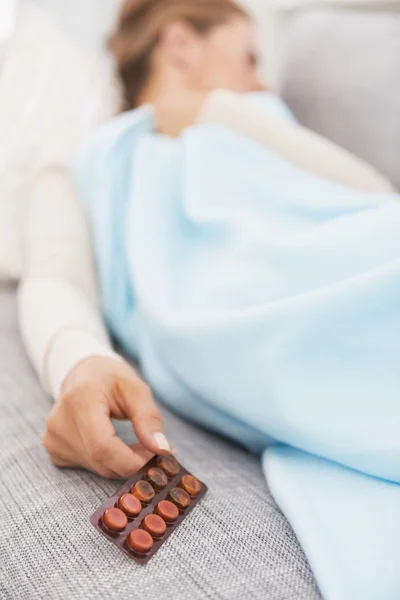 Primer plano en el paquete de pastillas en la mano de la mujer joven enferma — Foto de Stock