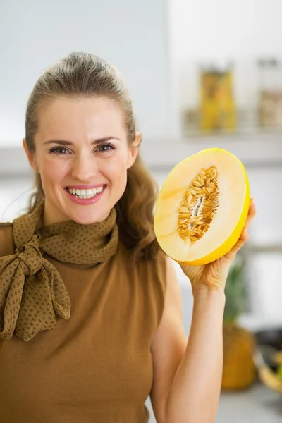 Happy young housewife holding melon slice — Stock Photo, Image
