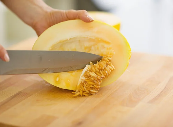 Close-up op vrouw zaden van meloen segment verwijderen — Stockfoto