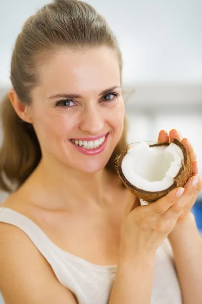 Portrait of happy young woman showing coconut — Stock Photo, Image