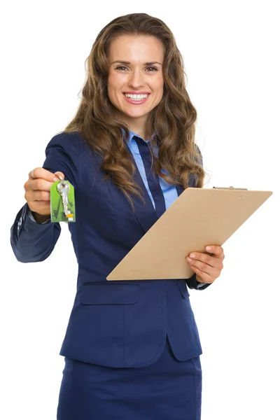 空白のクリップボードを表示するキーを持つ幸せな全米リアルター協会加入者の女性 — 图库照片