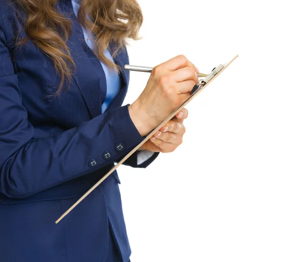 Closeup on business woman writing in clipboard — Stock Photo, Image