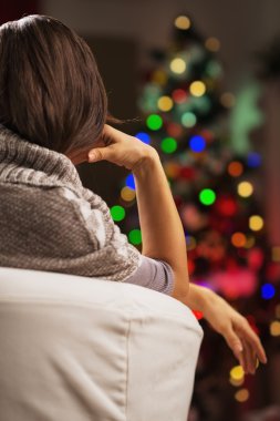koltuk Noel ağacı önünde oturan bir kadın. arka görünüm